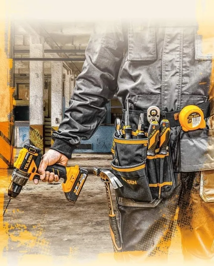 Tradesman wearing a Tolsen tool belt and holding a Tolsen cordless drill